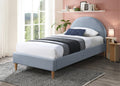 Bedroom with a blue upholstered bed, white bedding, and a pink wall.