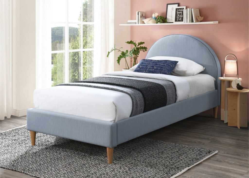 Bedroom with a blue upholstered bed, white bedding, and a pink wall.